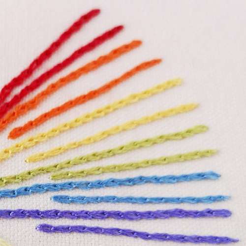 Regenbogen handgestickt auf weißem Leinenstoff